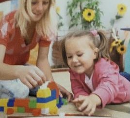 Teacher and child playing with building blocks
