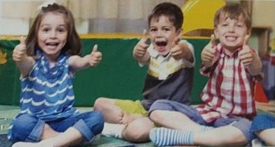 Three happy children showing thumbs up